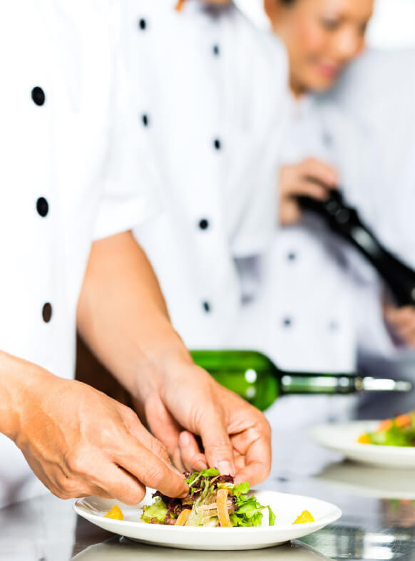 Penfield Olives food service olives and oils page image, chef plating a salad drizzled in olive oil.